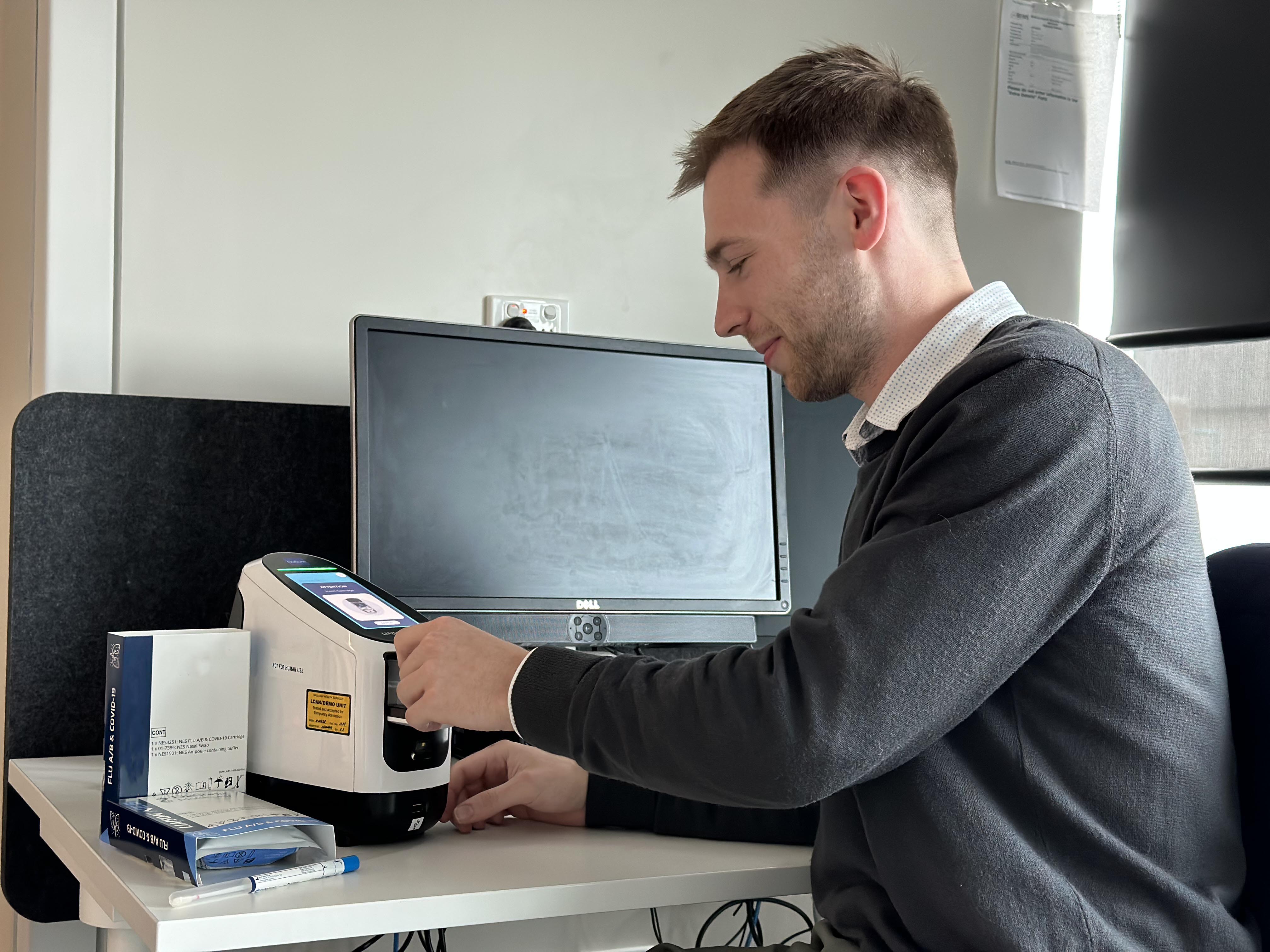 Michael Touhill, Clinical Trials Coordinator at Grampians Health, tests a sample using the new device.